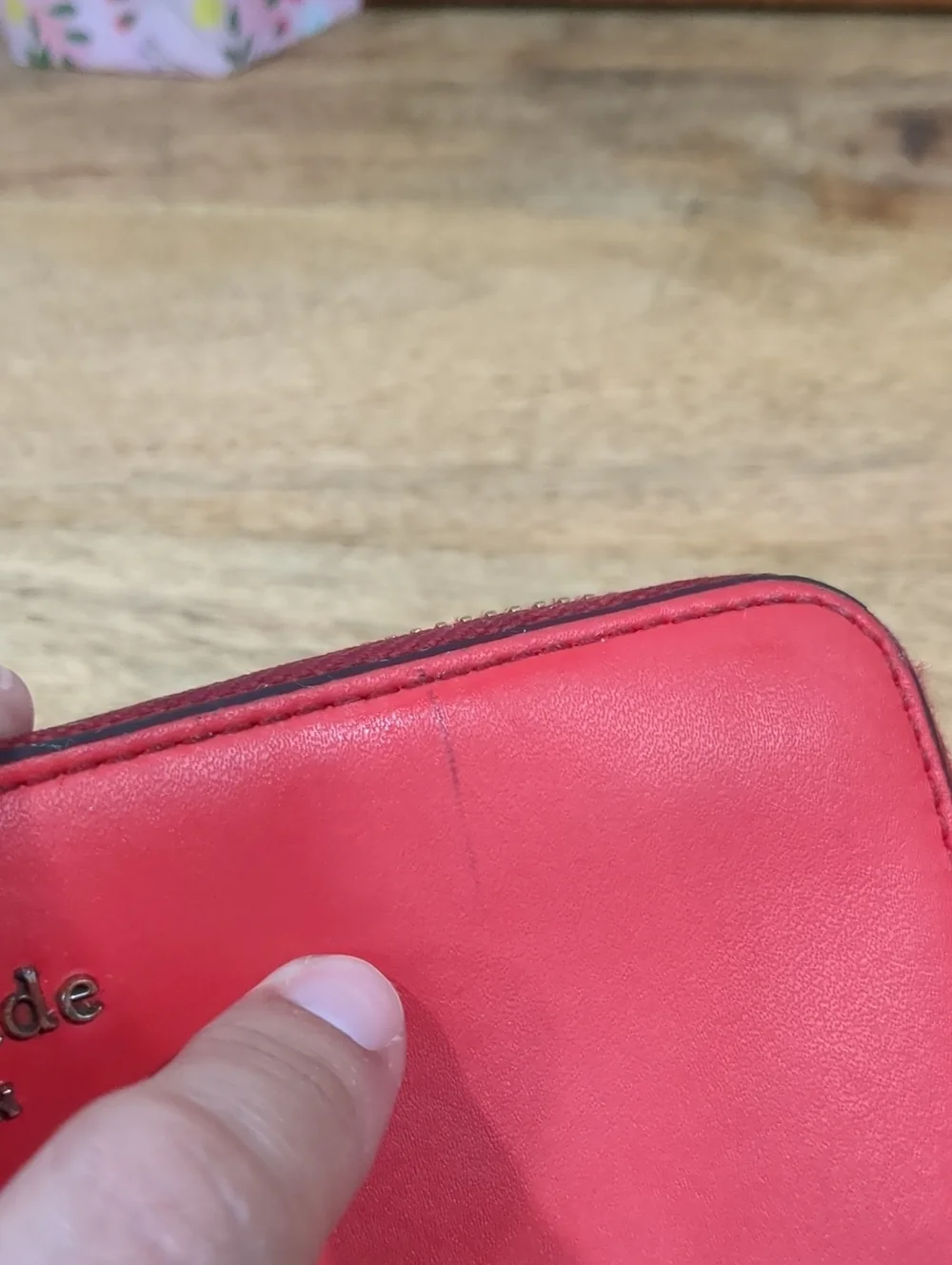 Kate Spade red zip-around wallet with Ace of Spades patch